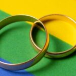 casamento homoafetivo? imagem de alianças sobre bandeira LGBT