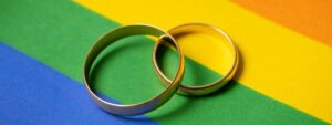 casamento homoafetivo? imagem de alianças sobre bandeira LGBT