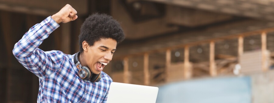 prova oral: jovem comemorando em frente a computador