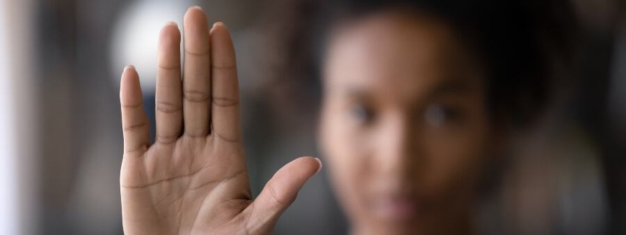 racismo: imagem de mulher negra fazendo sinal de "pare" com a mão