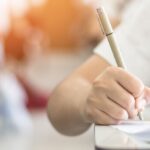 Dicas 2 fase oab: mão de aluno escrevendo em prova