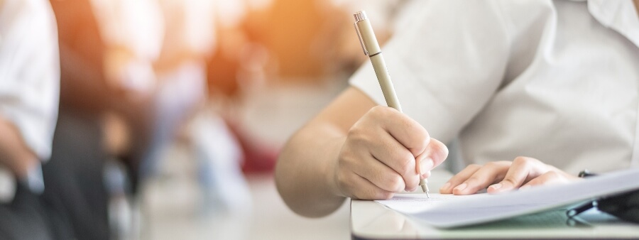 Dicas 2 fase oab: mão de aluno escrevendo em prova