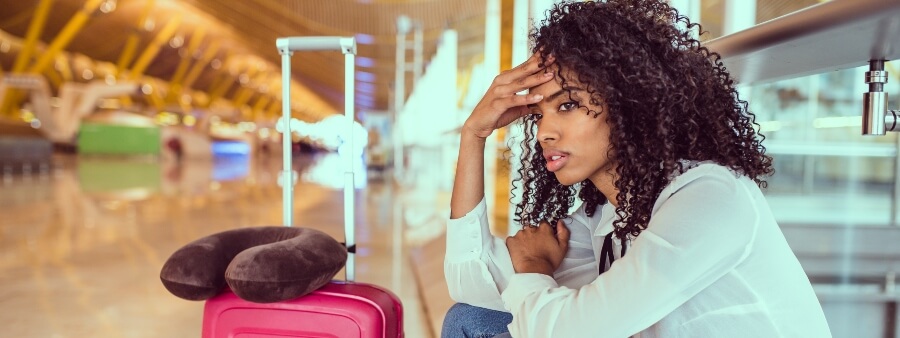 Show cancelado: imagem de mulher em aeroporto com semblante desapontado